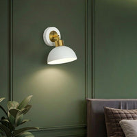 Wall light with white metal shade casting soft glow styled on green wall creating cozy ambient lighting for home decor.