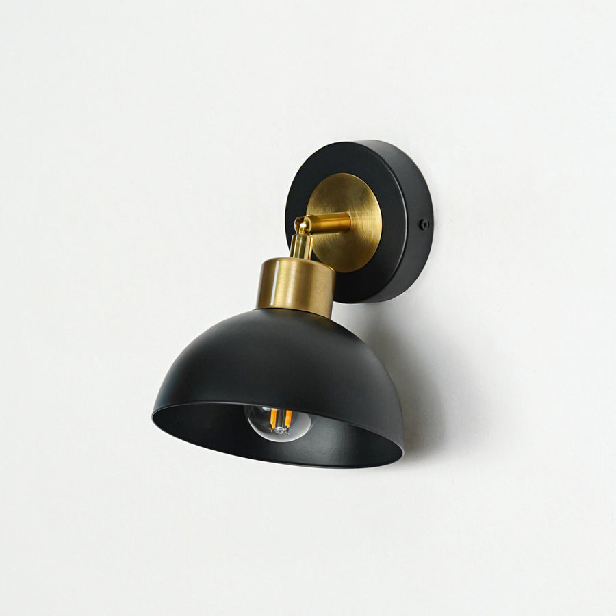 Black finish wall light with dome shade and gold mount perfect for modern interior wall decor placement on clean background.