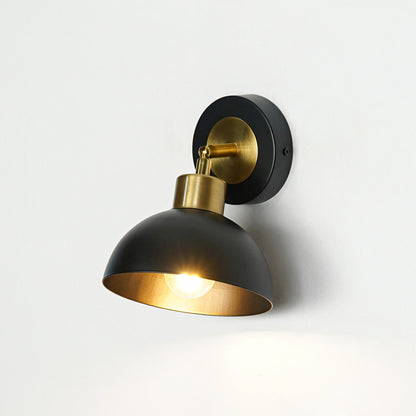 Black metal wall light with dome shade and gold holder emitting warm glow ideal for modern bedroom or hallway wall decor.