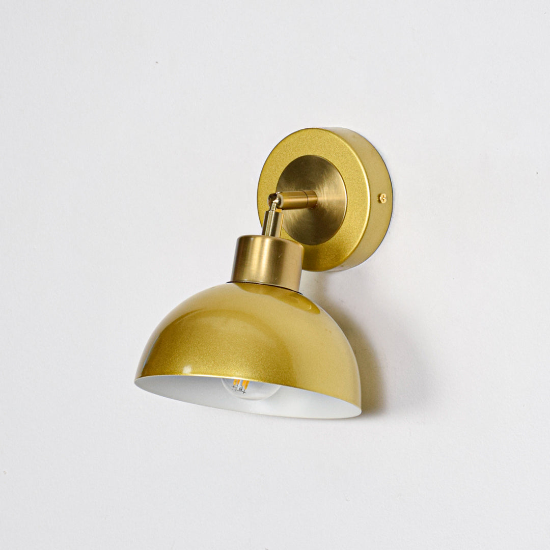 Gold metal wall light with dome shade and round mount ideal for modern bedroom or hallway wall decor placement on clean background.