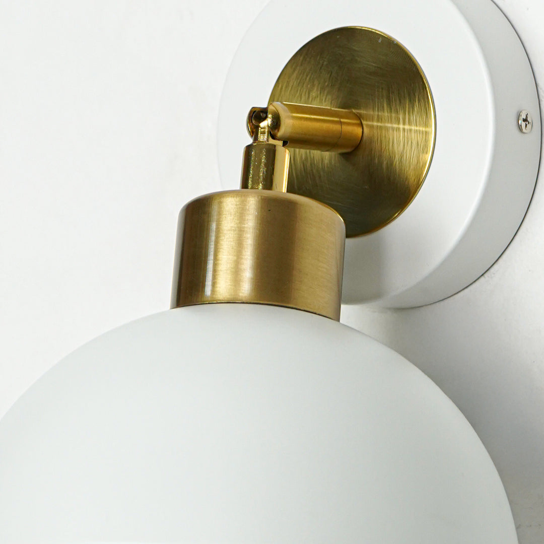 Closeup of wall light with white metal dome shade and gold holder showcasing smooth finish and premium detailing for interior decor.