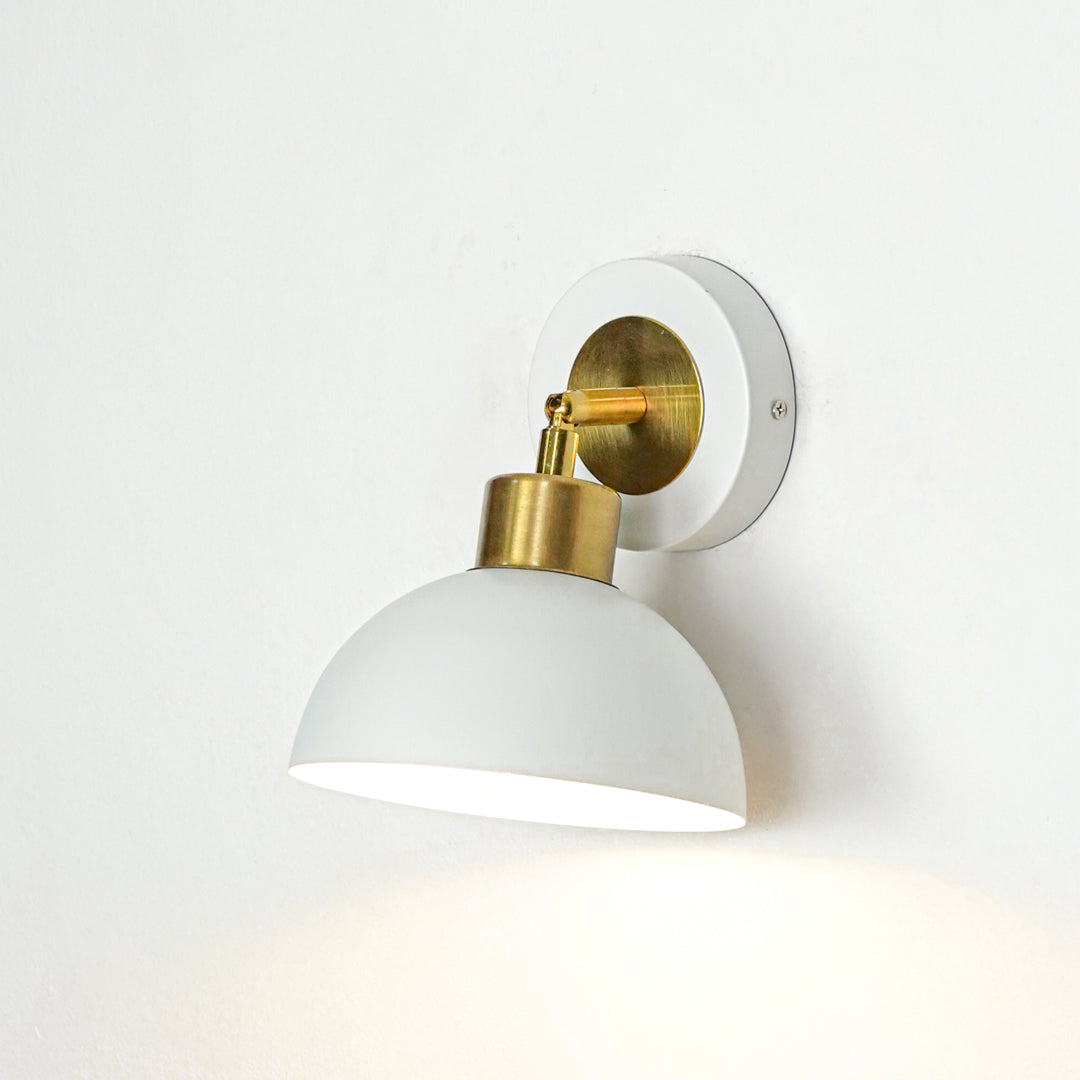 Wall light with white dome shade and gold metal mount ideal for bedroom or living room wall decor placement on clean background.
