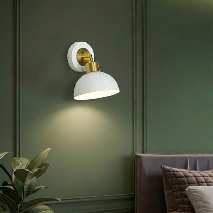 Wall light with white metal shade casting soft glow styled on green wall creating cozy ambient lighting for home decor.