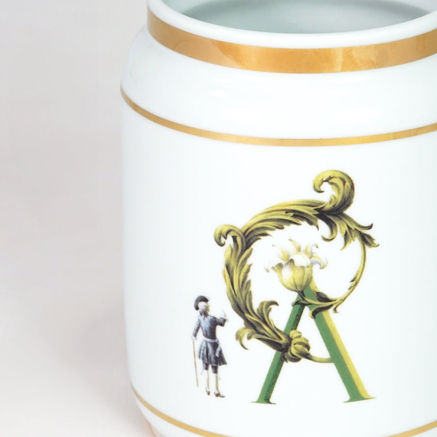 Closeup image of white ceramic decorative jar with gold detailing for luxury tabletop decor styling display.