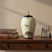 White ceramic decorative jar with black horse artwork styled on a wooden console for elegant contemporary home decor.