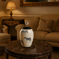 White ceramic jar with zebra design and crystal knob lid styled on table adding elegant safari charm to home decor.