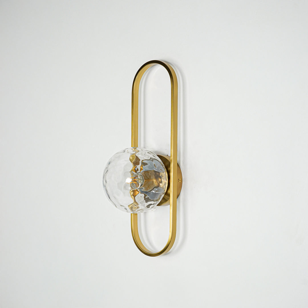Gold metal wall light with sculpted glass shade and sleek frame design perfect for modern interior wall decor on clean background.