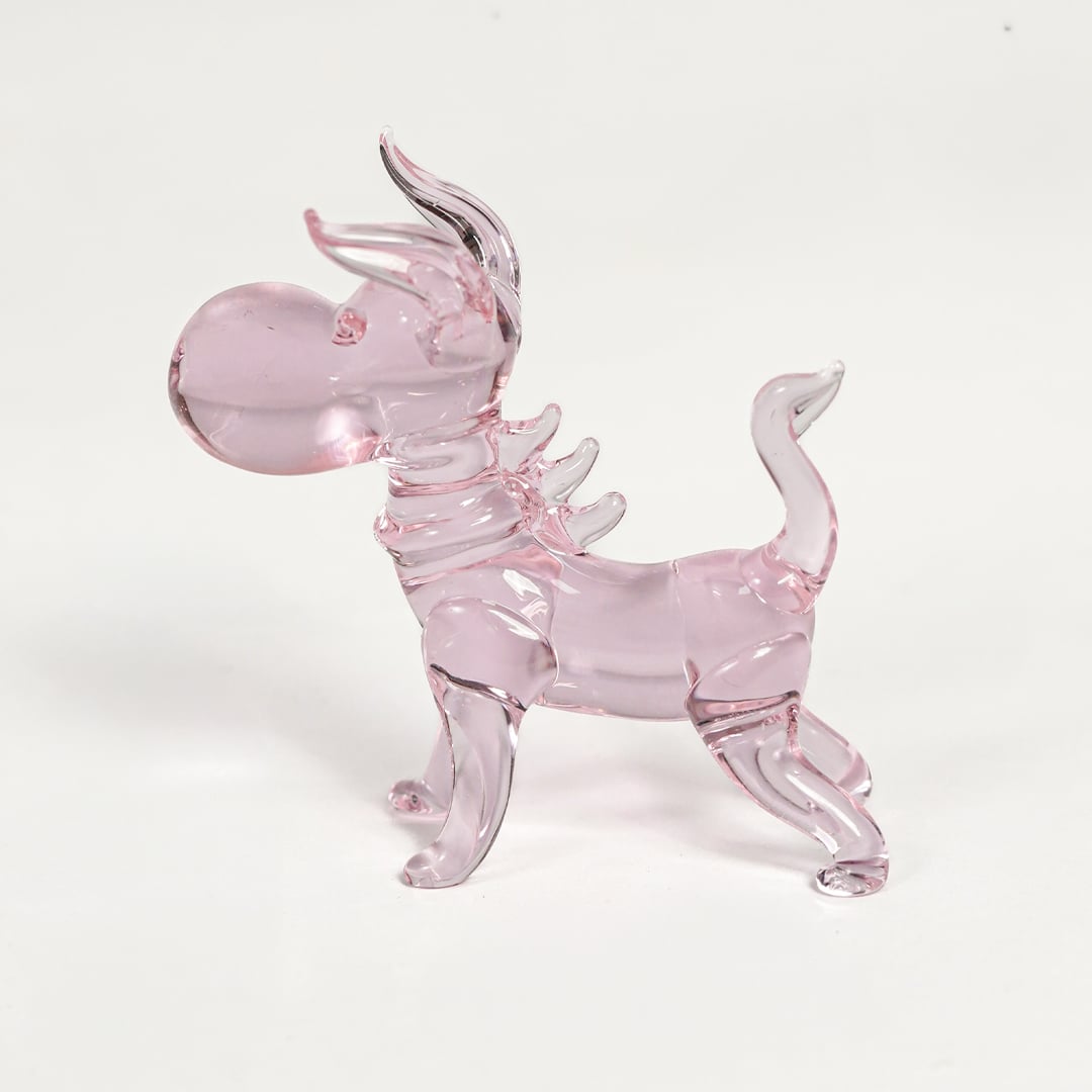 Pink glass dog figurine with glossy transparent finish isolated on white background for playful and cute decor display.