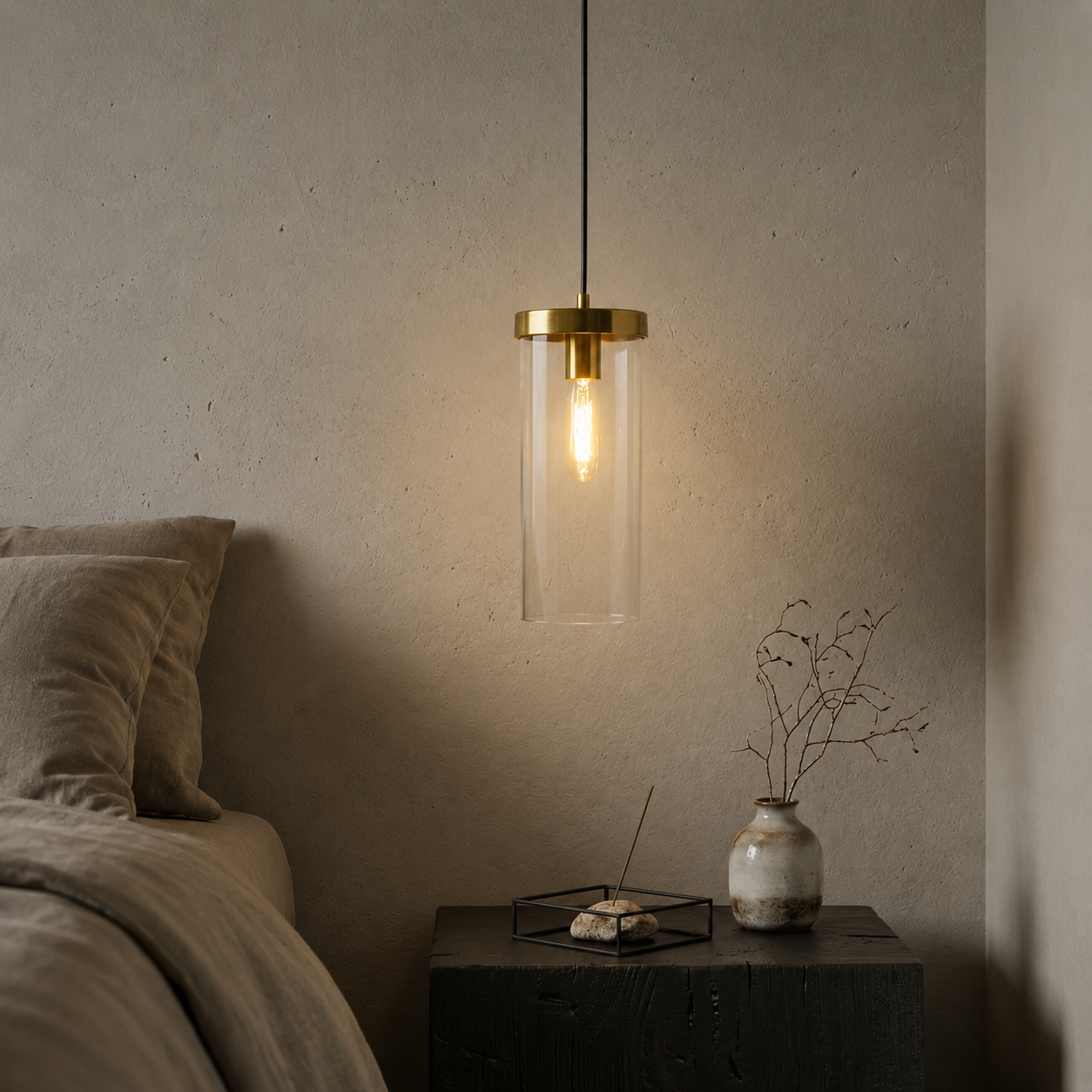 Brass and glass wall light casting warm glow beside bed in sophisticated bedroom interiors.