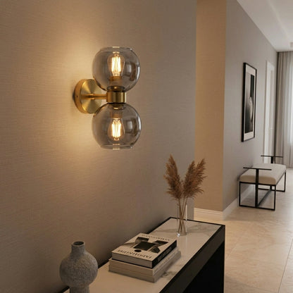 Dual glass globe wall light with gold base modern wall lamp for bedroom living room decor warm ambient lighting.

