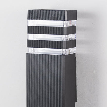 Closeup of tall black wall light showing precise detailing and clear acrylic light diffusers.