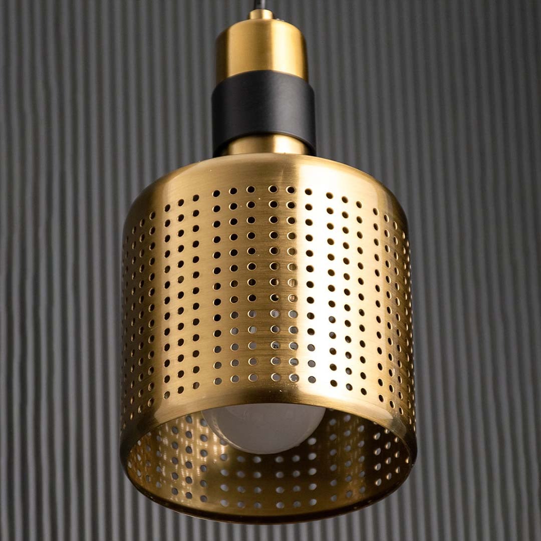 A closeup view of the gold perforated pendant light showing the dotted metal texture and warm interior tone ideal for stylish contemporary interiors.