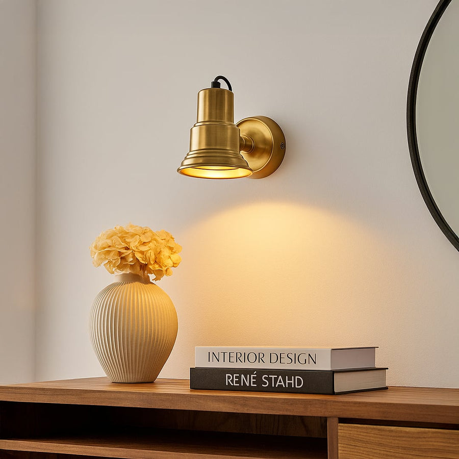 Modern gold metal wall light installed on interior wall providing directed ambient lighting for stylish home Decor.