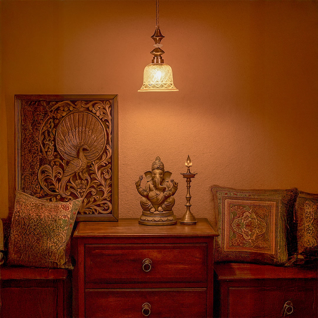 Patterned glass and gold metal pendant light illuminating bedroom decor with elegant ambient lighting.