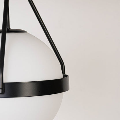 Closeup of black ceiling light with frosted glass globe shade and sleek frame for elegant modern ceiling lighting decor.