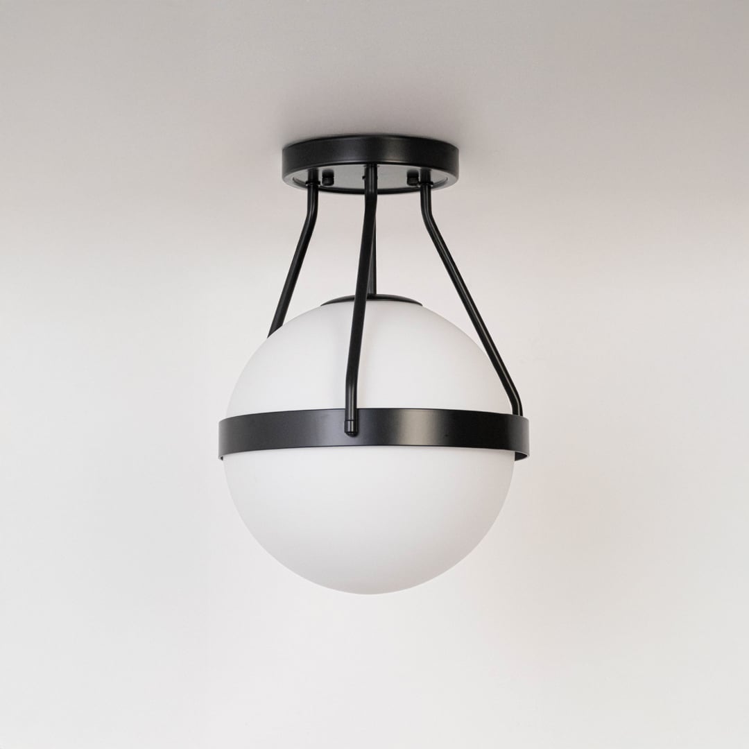 Black ceiling light with frosted glass globe and sleek modern frame in off mode on white background for home lighting.
