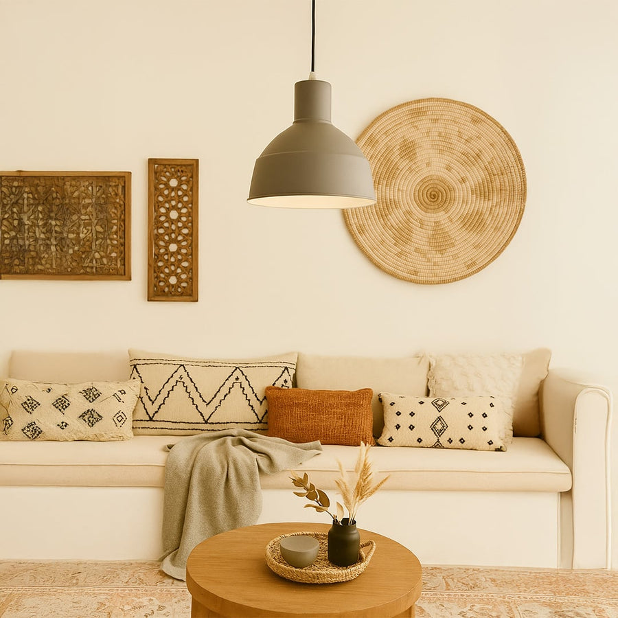 Grey pendant light illuminating a cozy bohemian living room with warm neutral tones and artistic decor.