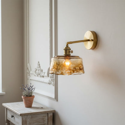 Modern amber glass and gold metal wall light for elegant bedroom and luxury living room decor spaces.