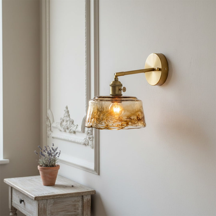 Modern amber glass and gold metal wall light for elegant bedroom and luxury living room decor spaces.