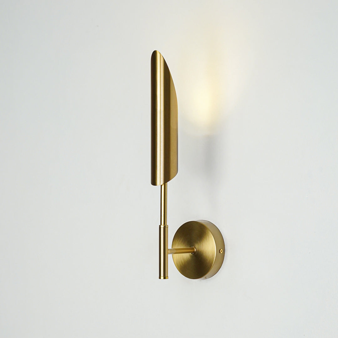 Gold metal wall light with vertical tube design emitting soft warm glow ideal for bedroom or hallway wall decor placement.