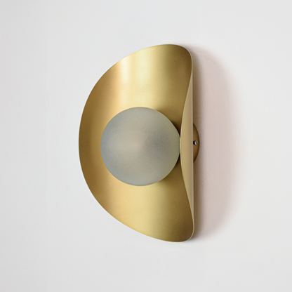 Wall light off on white background featuring sleek gold metal body with rounded profile and centered glass diffuser for minimalist product display.