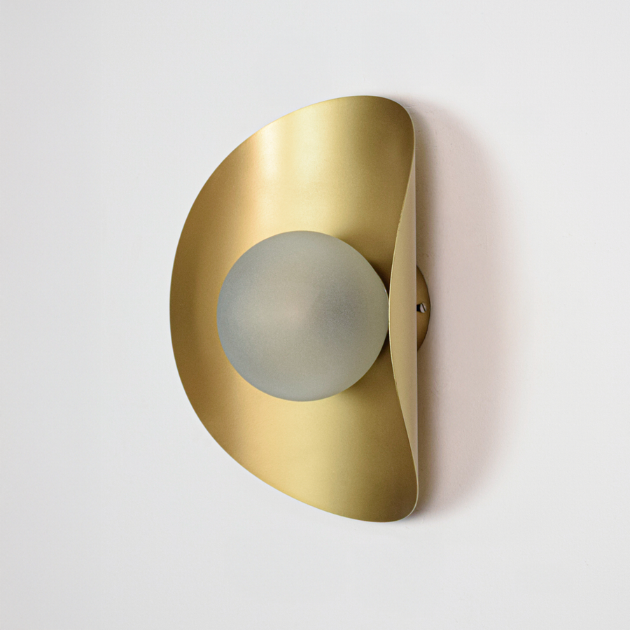 Wall light off on white background featuring sleek gold metal body with rounded profile and centered glass diffuser for minimalist product display.