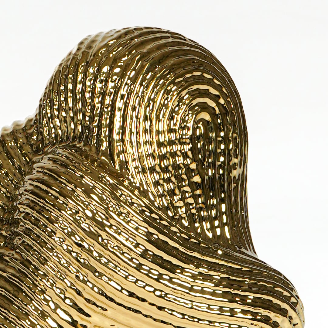 Textured gold metal artistic swirl sculpture for elegant shelf and console decor styling.