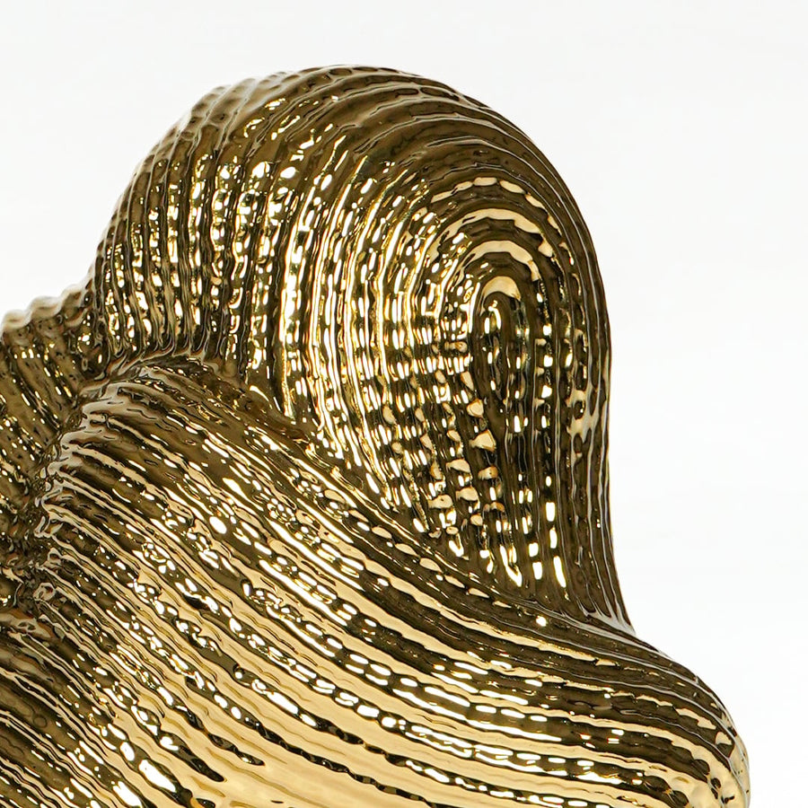 Textured gold metal artistic swirl sculpture for elegant shelf and console decor styling.