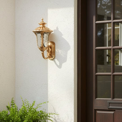 Gold outdoor wall light mounted beside entrance door on white exterior wall adding classic elegance and welcoming curb appeal to residential facade.