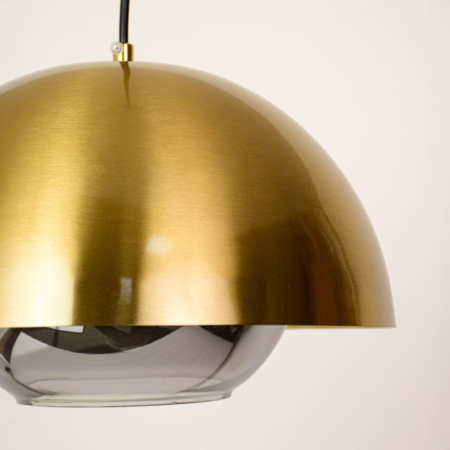 Closeup of brushed brass dome pendant light highlighting smooth curves and premium finish.