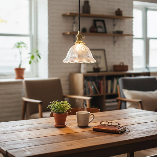 Ribbed clear glass and brass metal pendant light adding warm elegance above the dining table indoors.