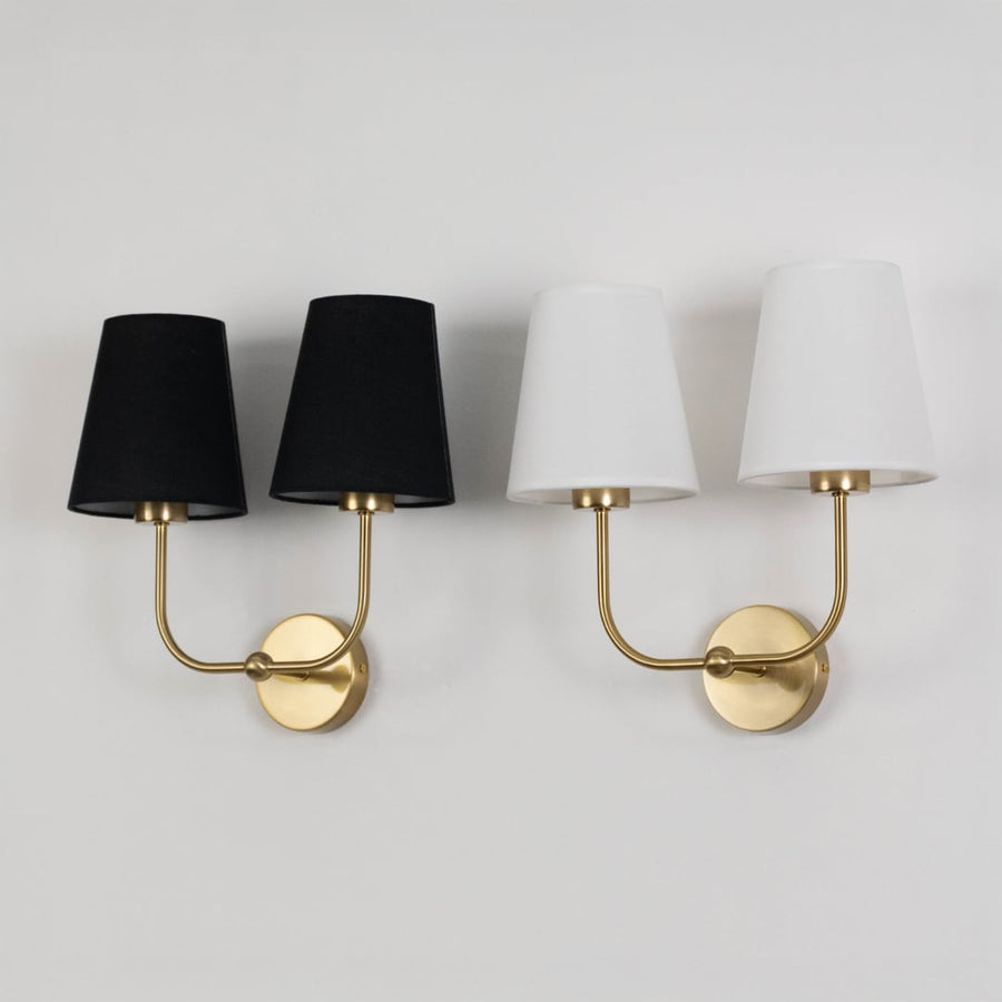 Double wall sconce with gold frame and black fabric shades shown on a white background with lights off.