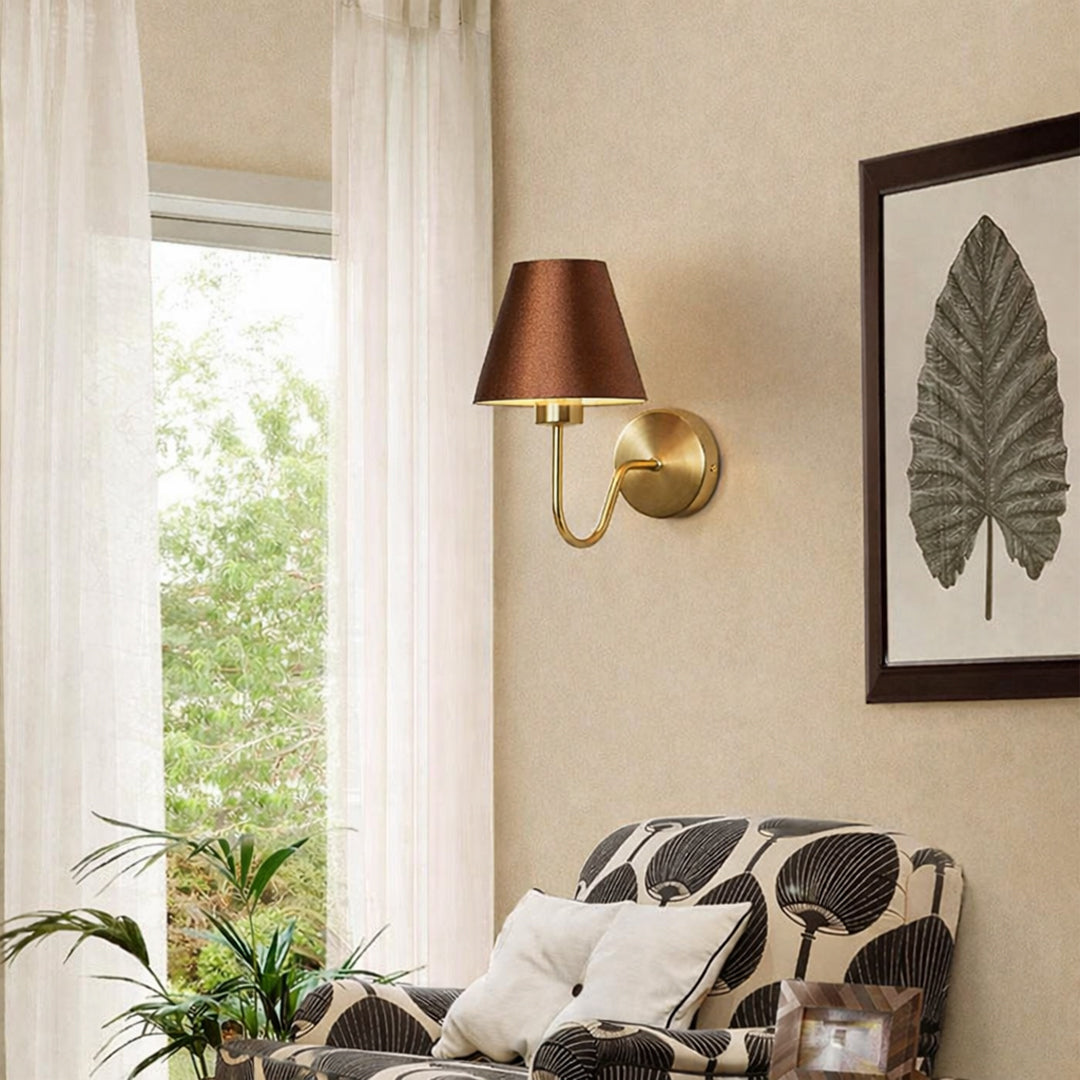 Elegant wall light in gold metal finish with fabric shade for living room decor lighting placement lifestyle image.