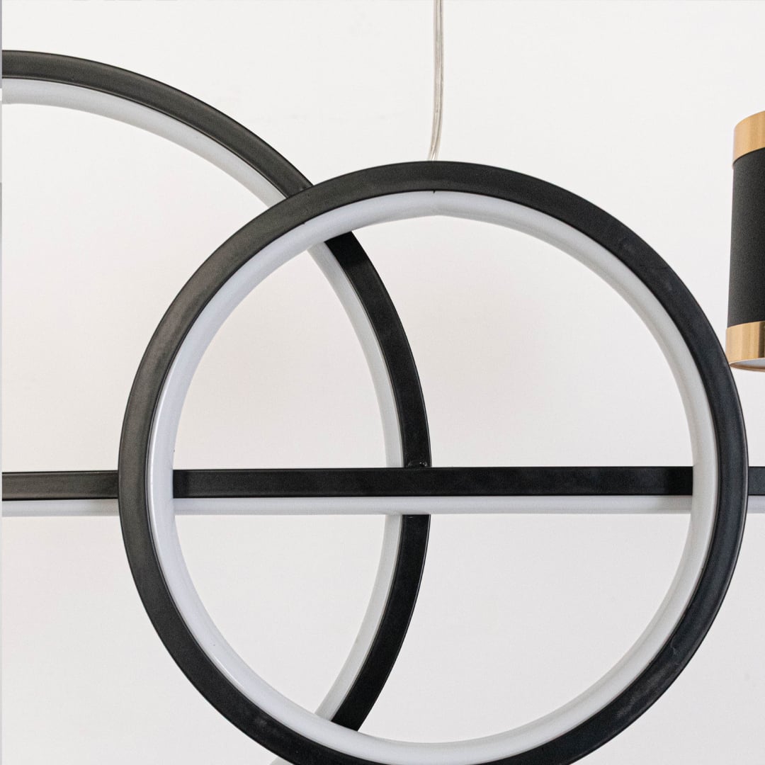 Closeup of pendant light featuring golden ring frame and dual cylindrical spotlights for modern home ceiling lighting decor.