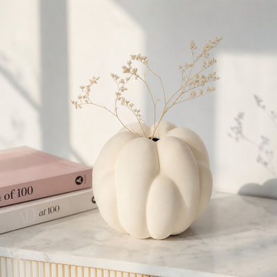 Cream textured ceramic vase placed on marble table for elegant contemporary home decor styling.