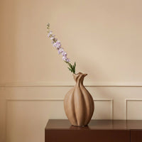 Beige ceramic decorative vase with sculpted organic petal shape perfect for dried flower display on console table and modern home decor.