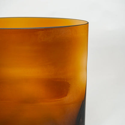 Close up view amber glass planter showing smooth surface rich color modern decorative glass accent for home styling.