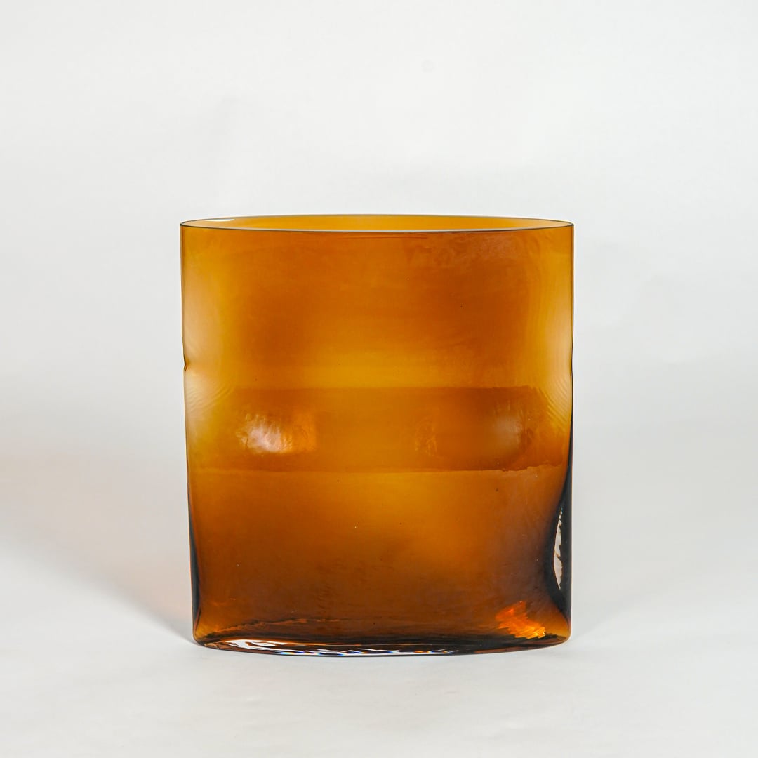 Amber decorative glass planter on white background modern home decor accent piece for table floor console styling interior.