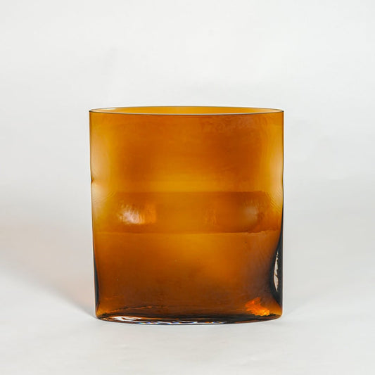Amber decorative glass planter on white background modern home decor accent piece for table floor console styling interior.