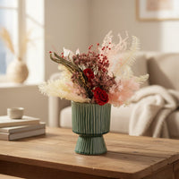 Green ceramic decorative vase styled with dried flowers on a wooden table for elegant modern home decor settings.