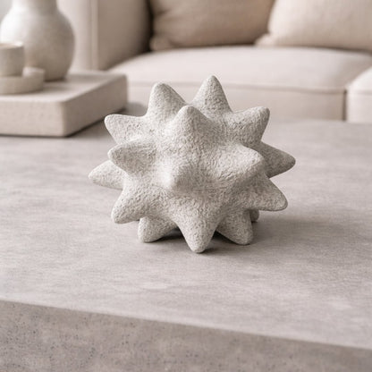White ceramic star shaped decorative accent placed on coffee table creating subtle and contemporary interior decor charm.