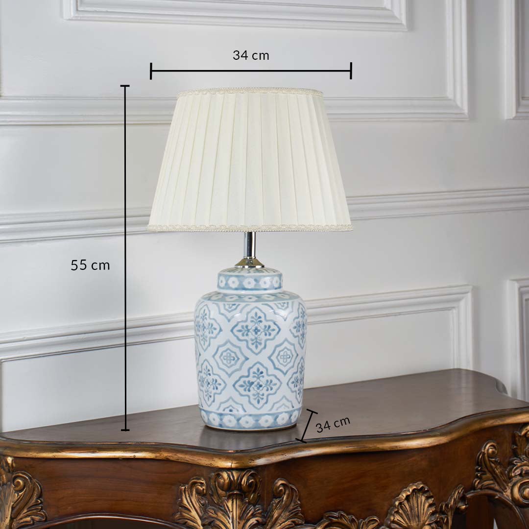 Blue and white ceramic table lamp with pleated beige shade displayed on white background featuring height 55 cm and width 34 cm for accurate size reference.