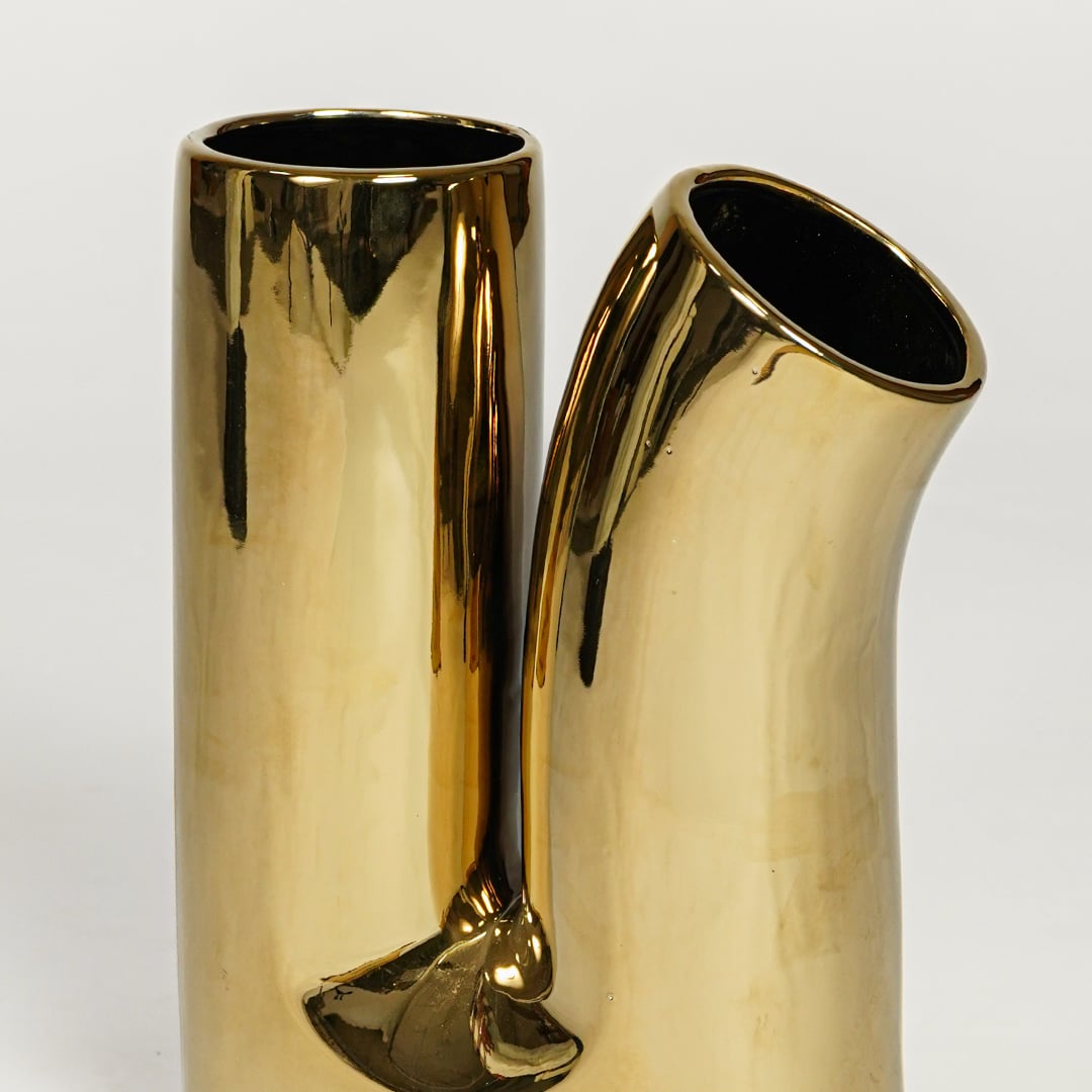 Glossy gold metal designer vase with artistic double spout form for elegant console and entryway decor.