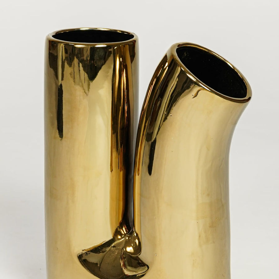 Glossy gold metal designer vase with artistic double spout form for elegant console and entryway decor.
