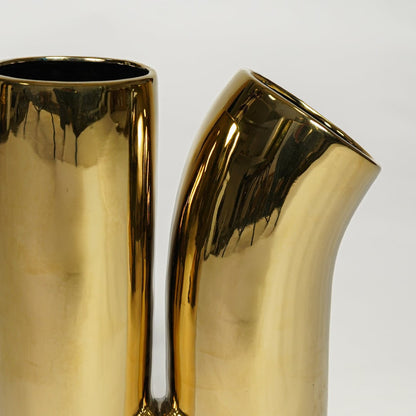 Reflective gold metal contemporary vase with curved neck design for tabletop and office decor styling.