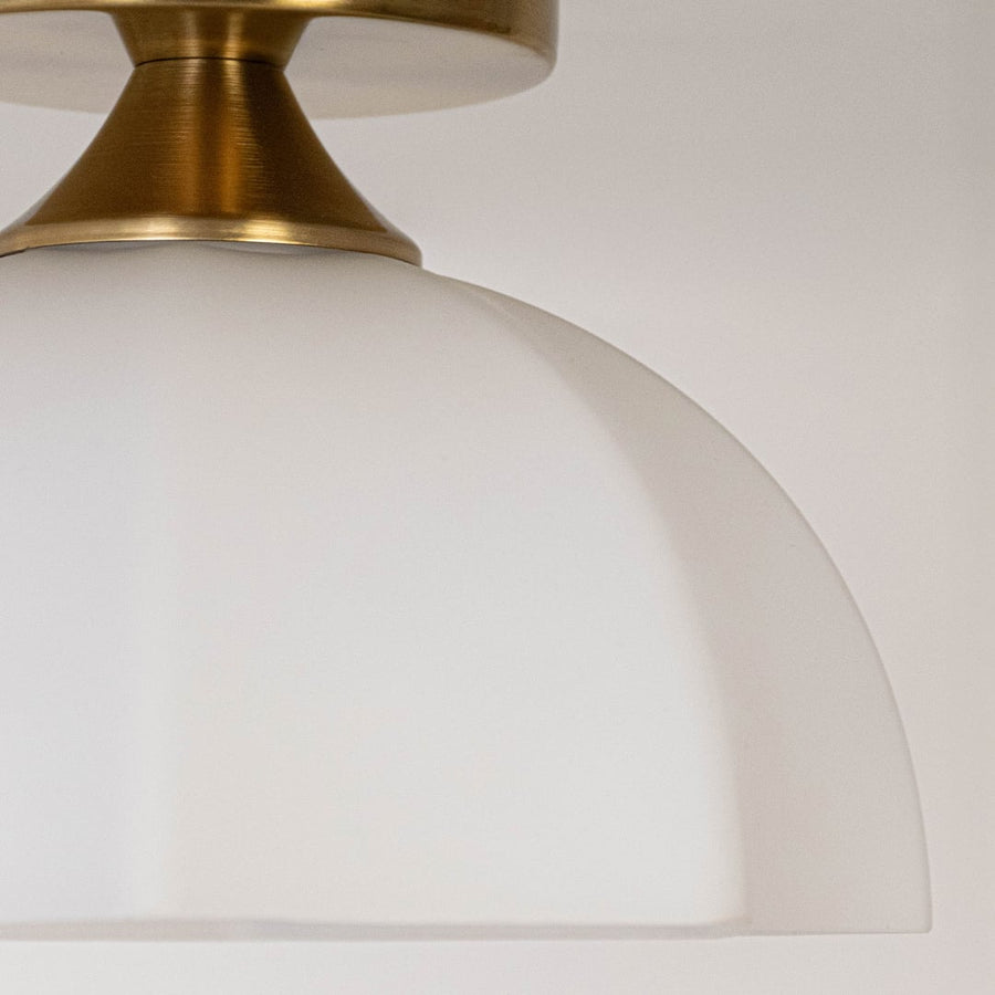 Closeup of white glass shade and gold metal ceiling light for elegant interior decor and premium styling spaces.