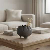 Dark grey textured bowl planter with dried stems on coffee table for elegant modern living room home interior decor.