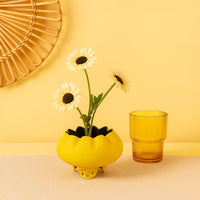 Yellow metal scalloped bowl planter decor styled in a warm modern room adding a bright elegant accent to living room tables.