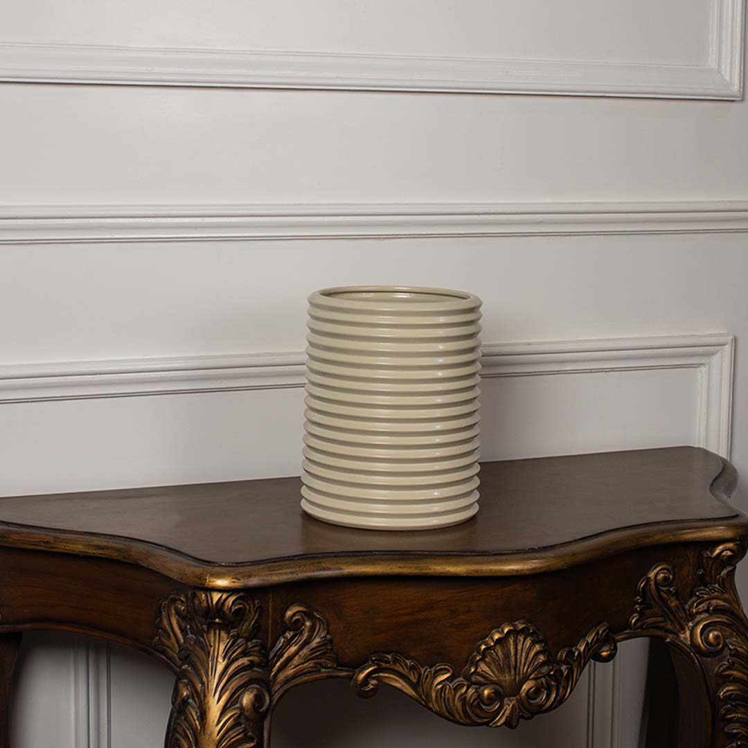 Beige ribbed ceramic vase with glossy texture shown on white background perfect for minimalist home decor styling.