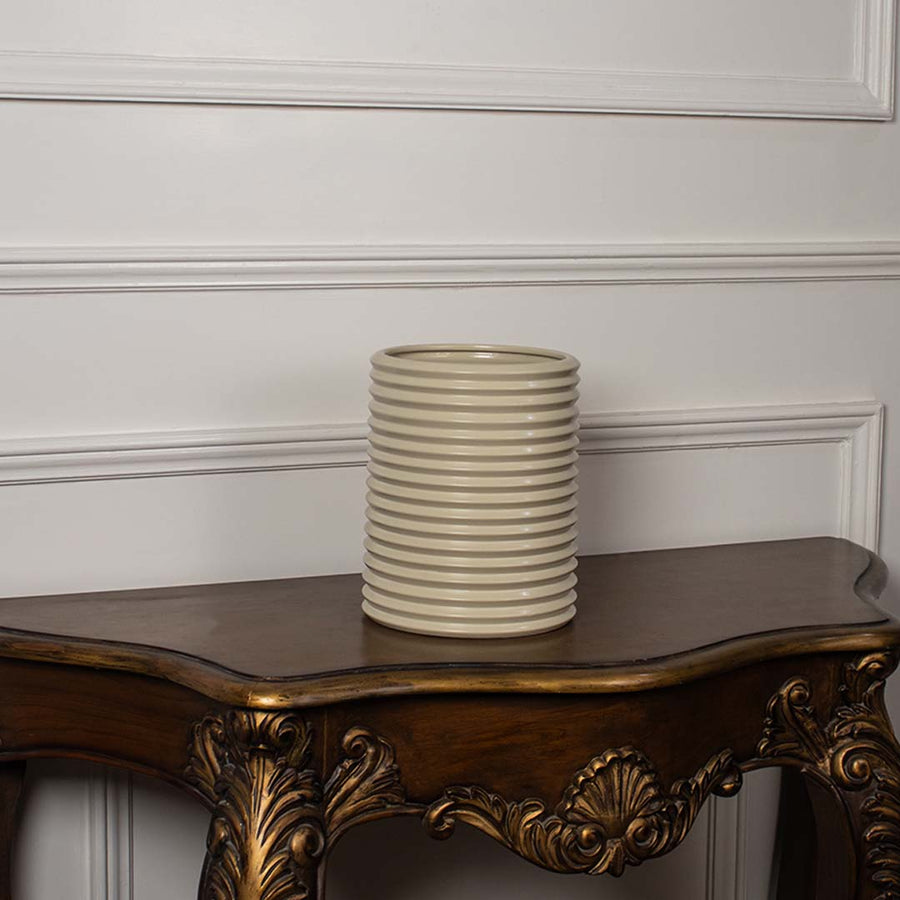 Beige ribbed ceramic vase with glossy texture shown on white background perfect for minimalist home decor styling.